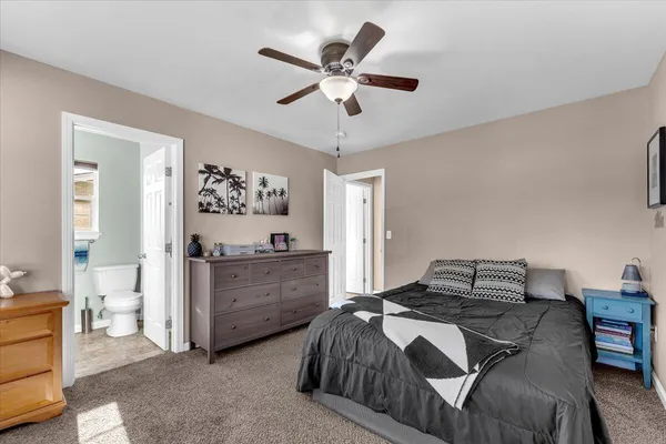 a bedroom with a bed and a ceiling fan
