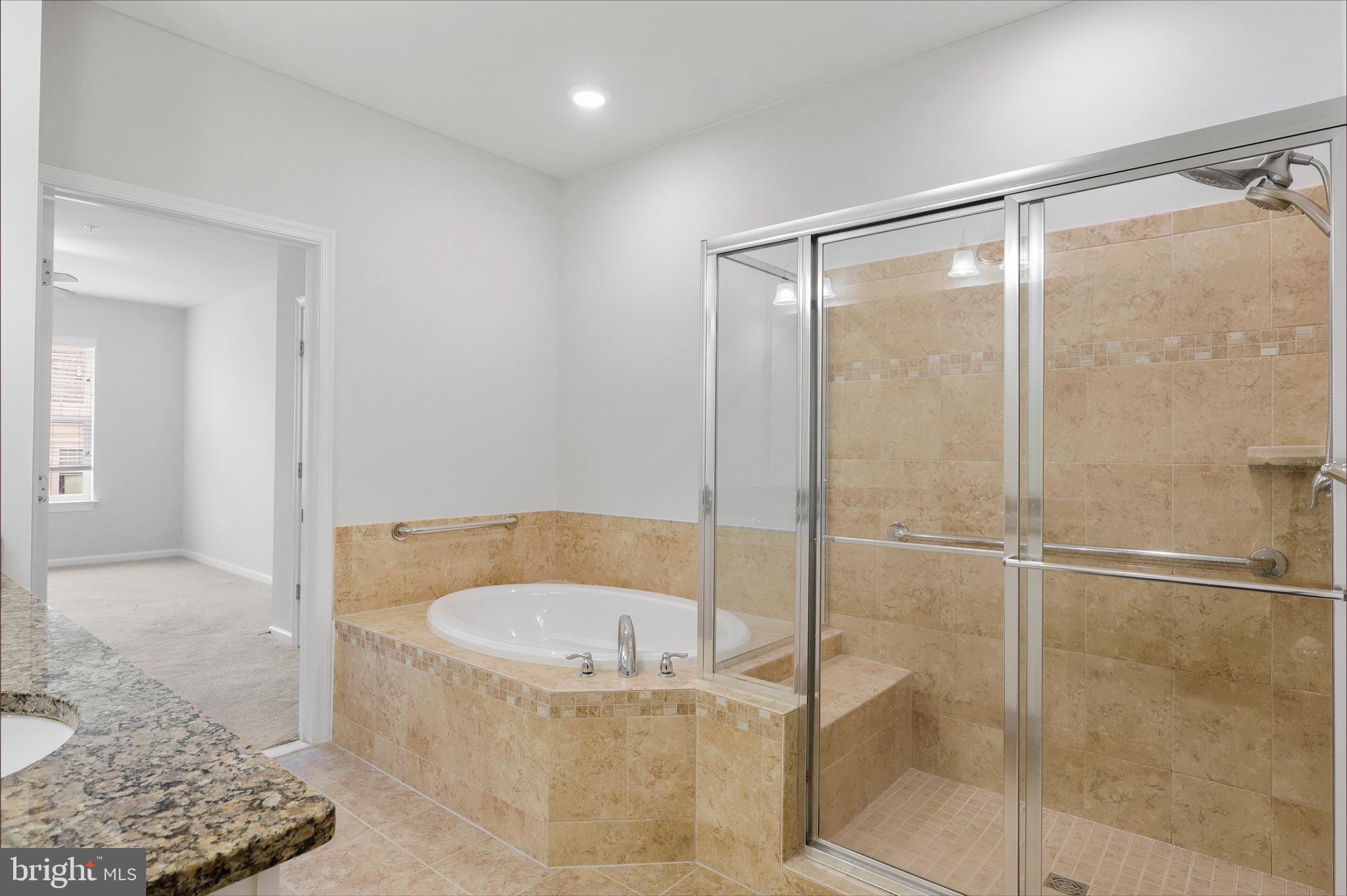 20655 Hope Spring Terrace, Unit 403 Ashburn, VA 20147 - Photo 12 of 21 a bathroom with a tub and shower