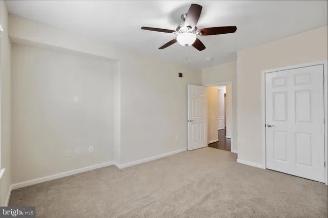 an empty room with closet and a chandelier fan