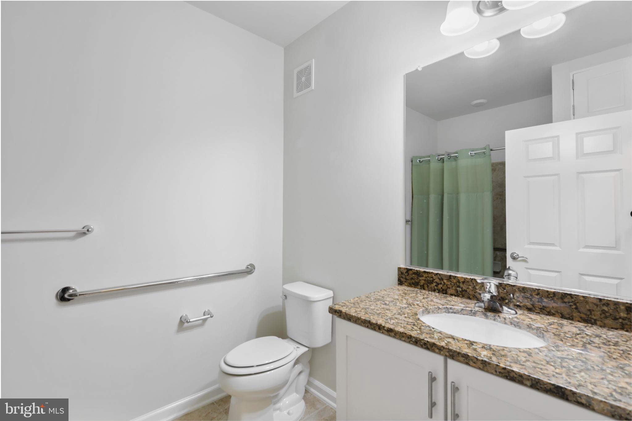 20655 Hope Spring Terrace, Unit 403 Ashburn, VA 20147 - Photo 16 of 21 a bathroom with a granite countertop sink a toilet and a mirror