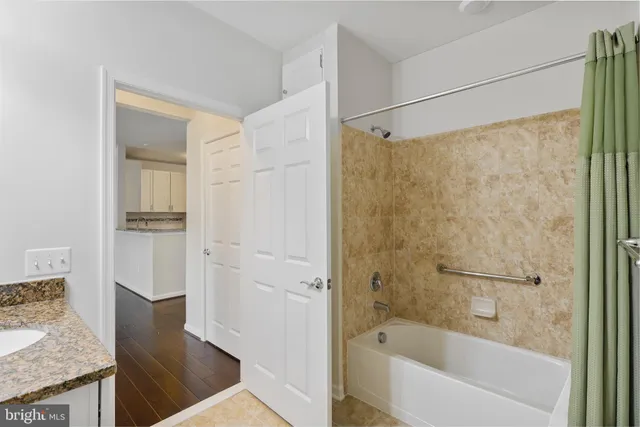 a bathroom with a granite countertop bathtub shower and vanity