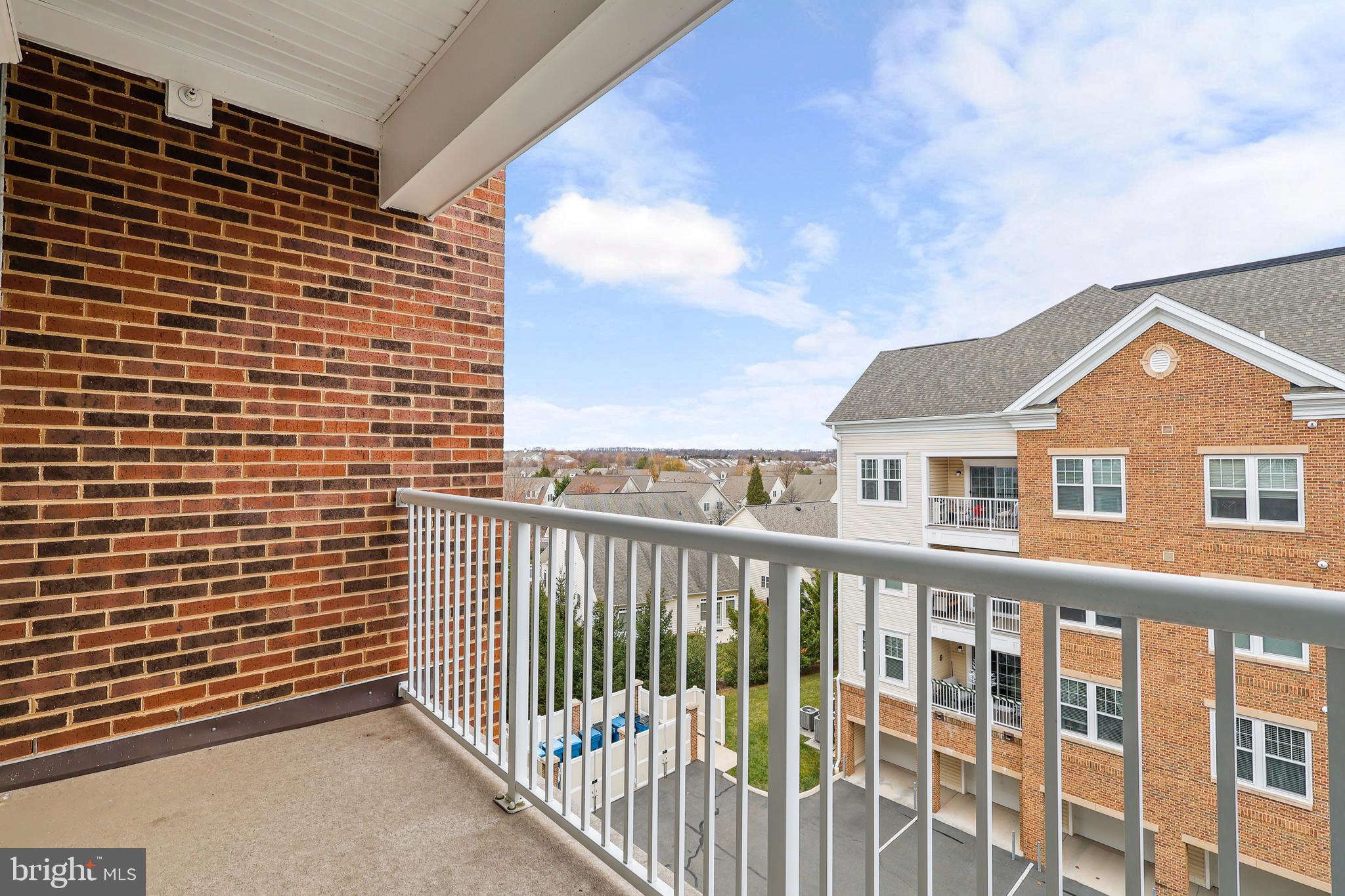 20655 Hope Spring Terrace, Unit 403 Ashburn, VA 20147 - Photo 19 of 21 a view of a brick house with wooden fence