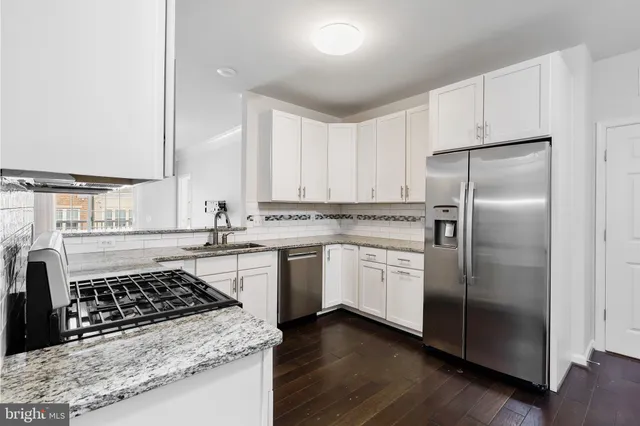 a kitchen with white cabinets and appliances