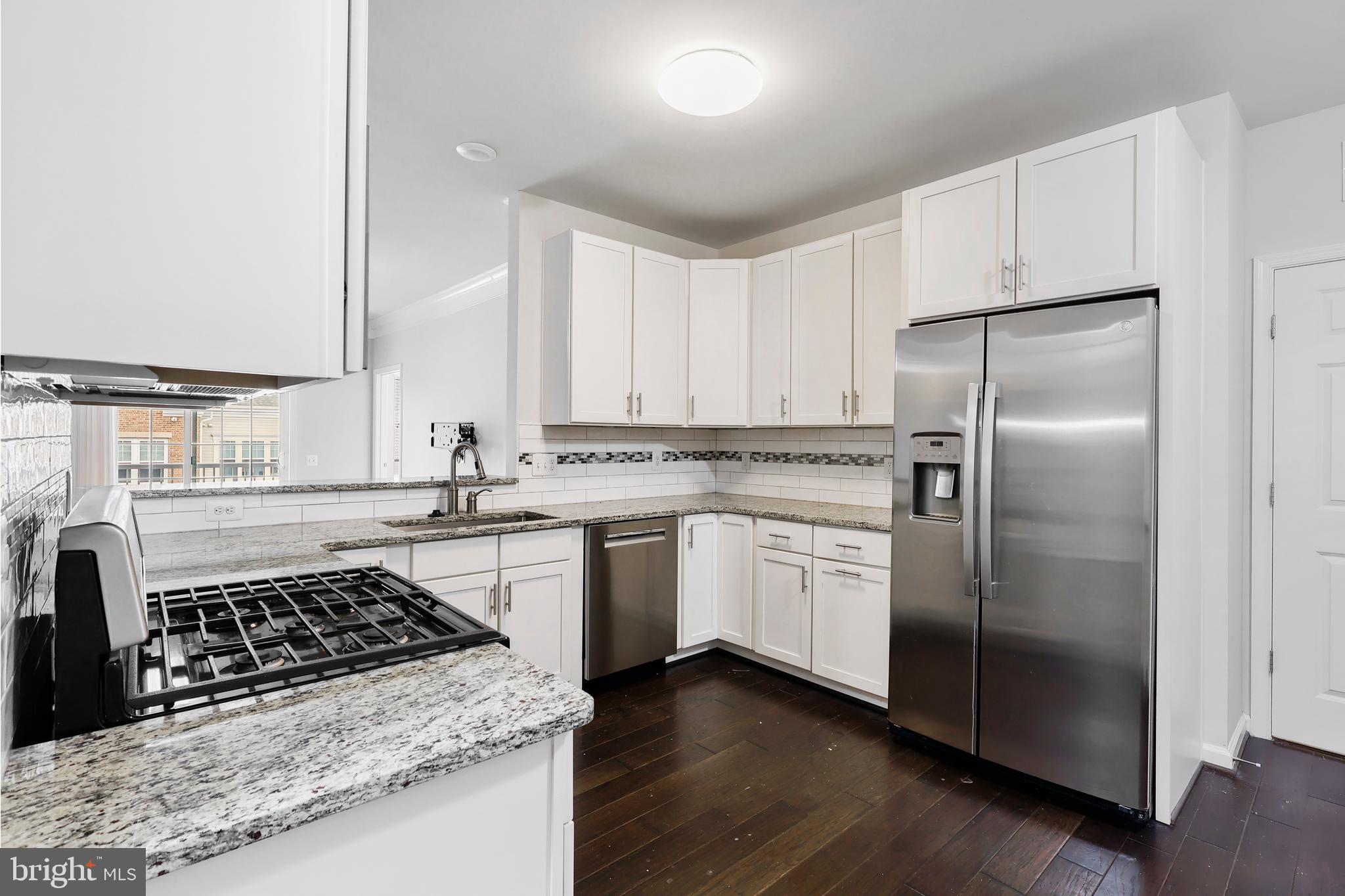 20655 Hope Spring Terrace, Unit 403 Ashburn, VA 20147 - Photo 7 of 21 a kitchen with white cabinets and appliances