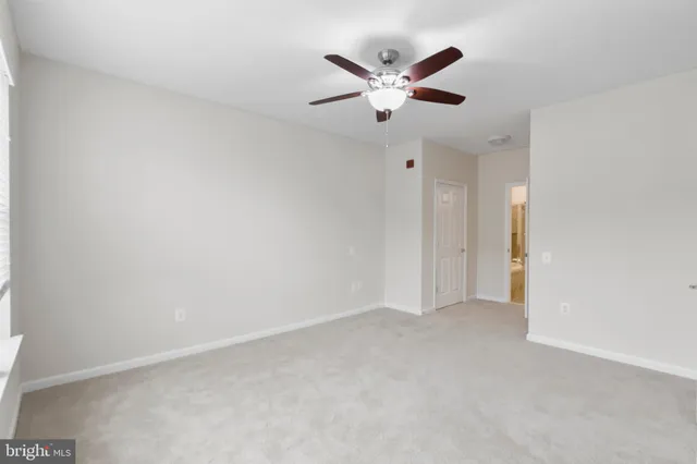 an empty room with closet and a chandelier fan