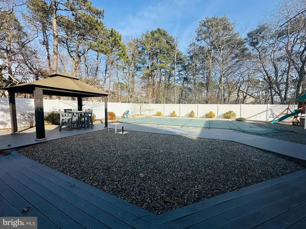 a view of a yard with wooden fence