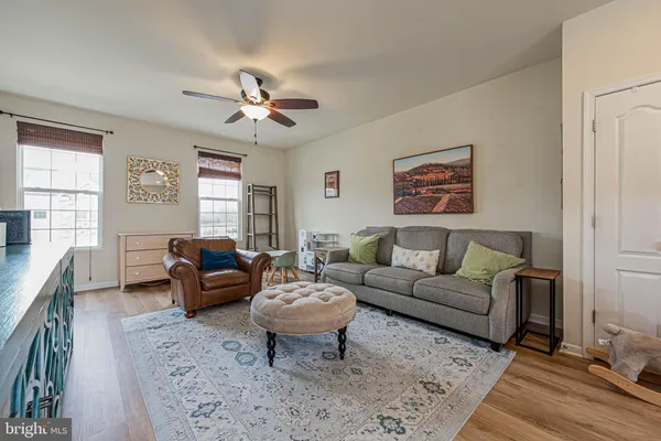 a living room with furniture two windows and a chandelier