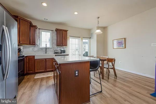 a kitchen with kitchen island granite countertop wooden floors and stainless steel appliances