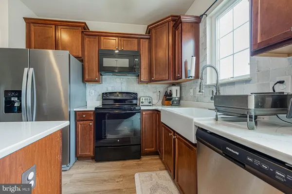 a kitchen with stainless steel appliances a sink cabinets and a wooden floor