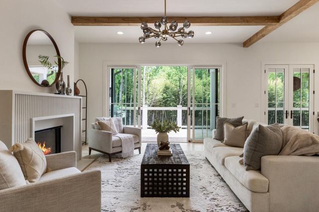 a living room with furniture a fireplace and a chandelier