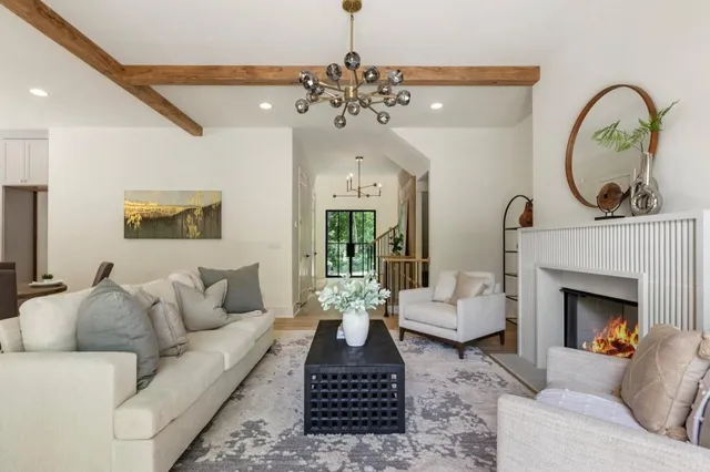 a living room with furniture a fireplace and a chandelier