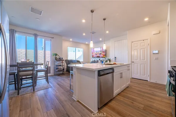 a kitchen with stainless steel appliances granite countertop wooden floors and sink