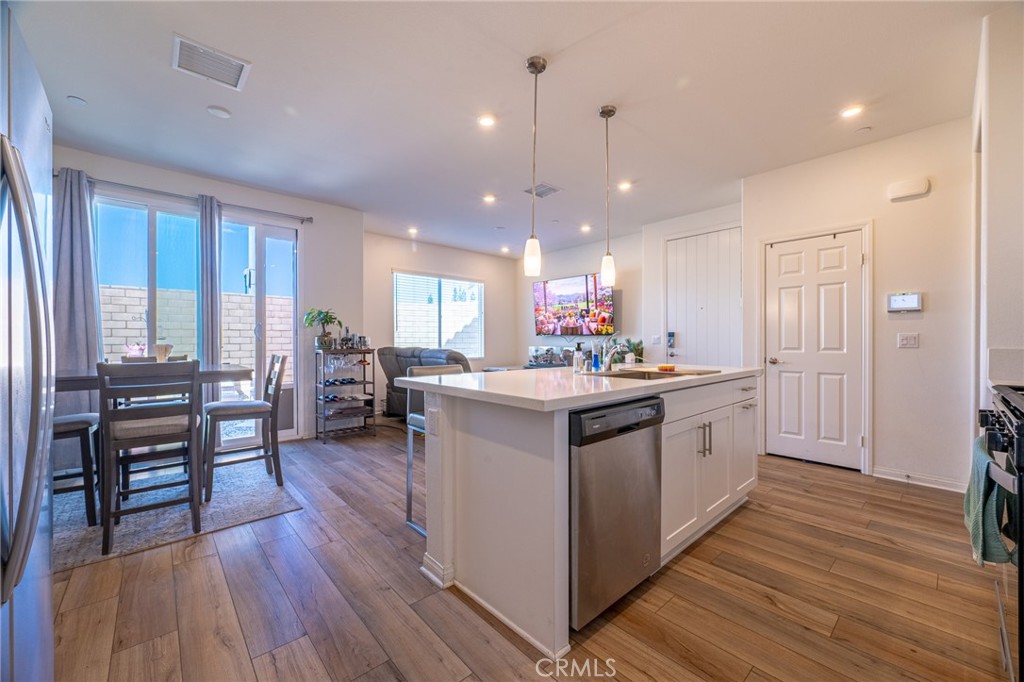 202 Bonita Lane Rialto, CA 92376 - Photo 11 of 43 a kitchen with stainless steel appliances granite countertop wooden floors and sink