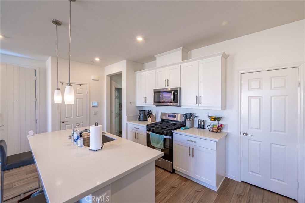 202 Bonita Lane Rialto, CA 92376 - Photo 14 of 43 a kitchen with stainless steel appliances a white table chairs and a refrigerator