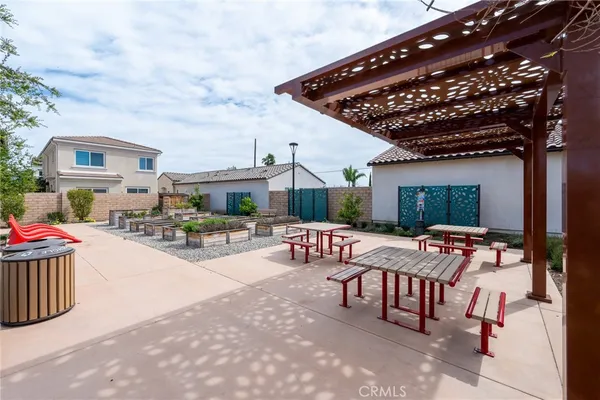 a view of a patio with table and chairs with a barbeque grill and plants