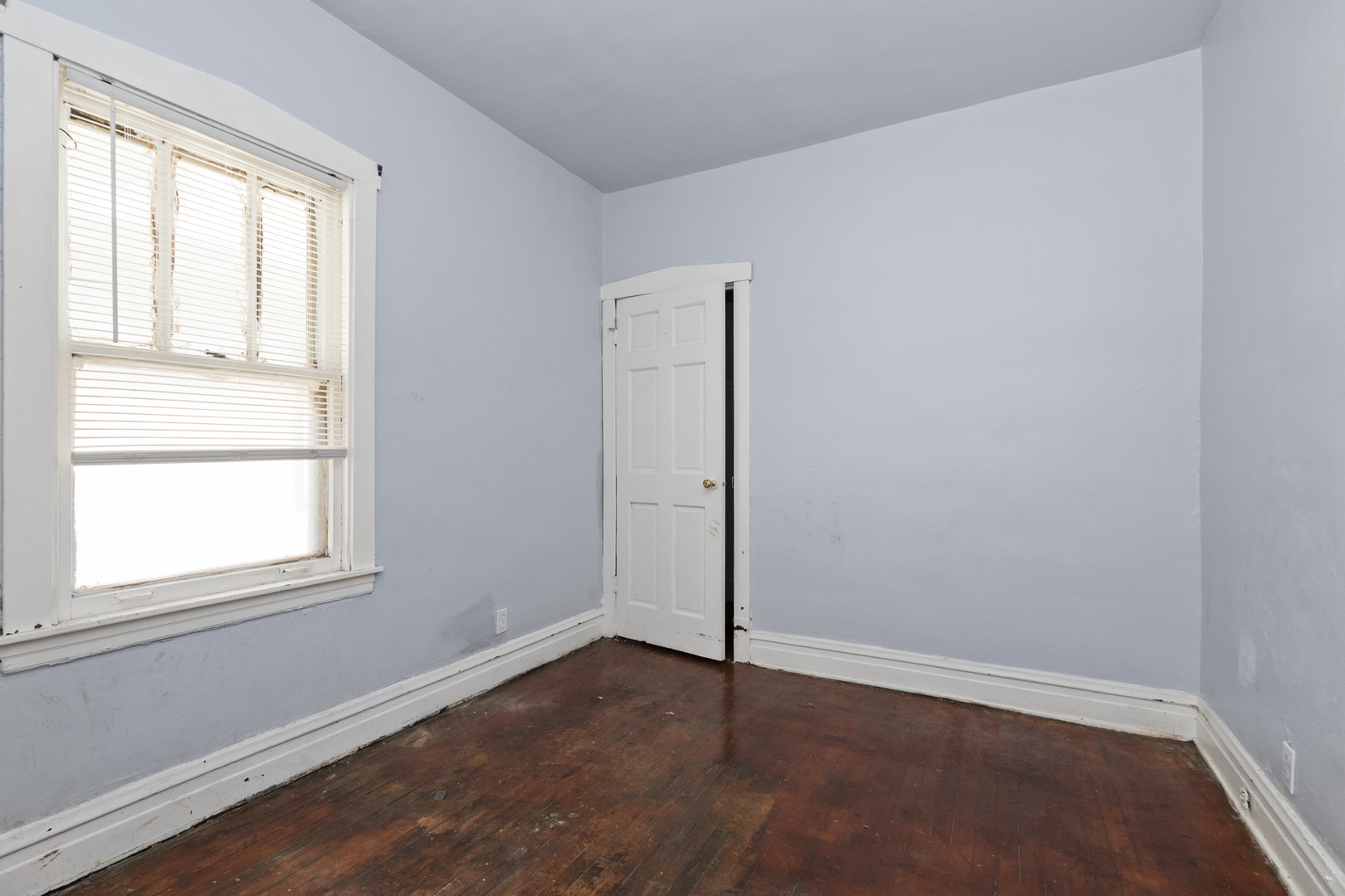 12050 South Yale Avenue Chicago, IL 60628 - Photo 11 of 24 an empty room with wooden floor and windows