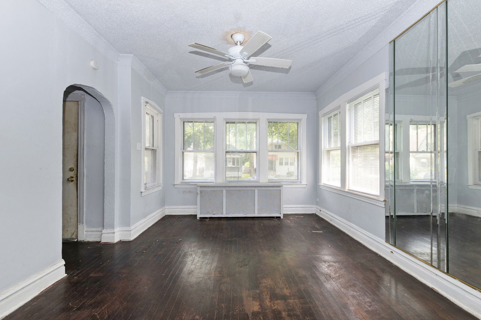 12050 South Yale Avenue Chicago, IL 60628 - Photo 5 of 24 an empty room with wooden floor fan and windows