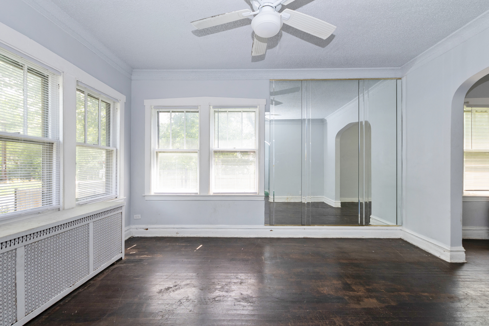 12050 South Yale Avenue Chicago, IL 60628 - Photo 6 of 24 an empty room with wooden floor and windows