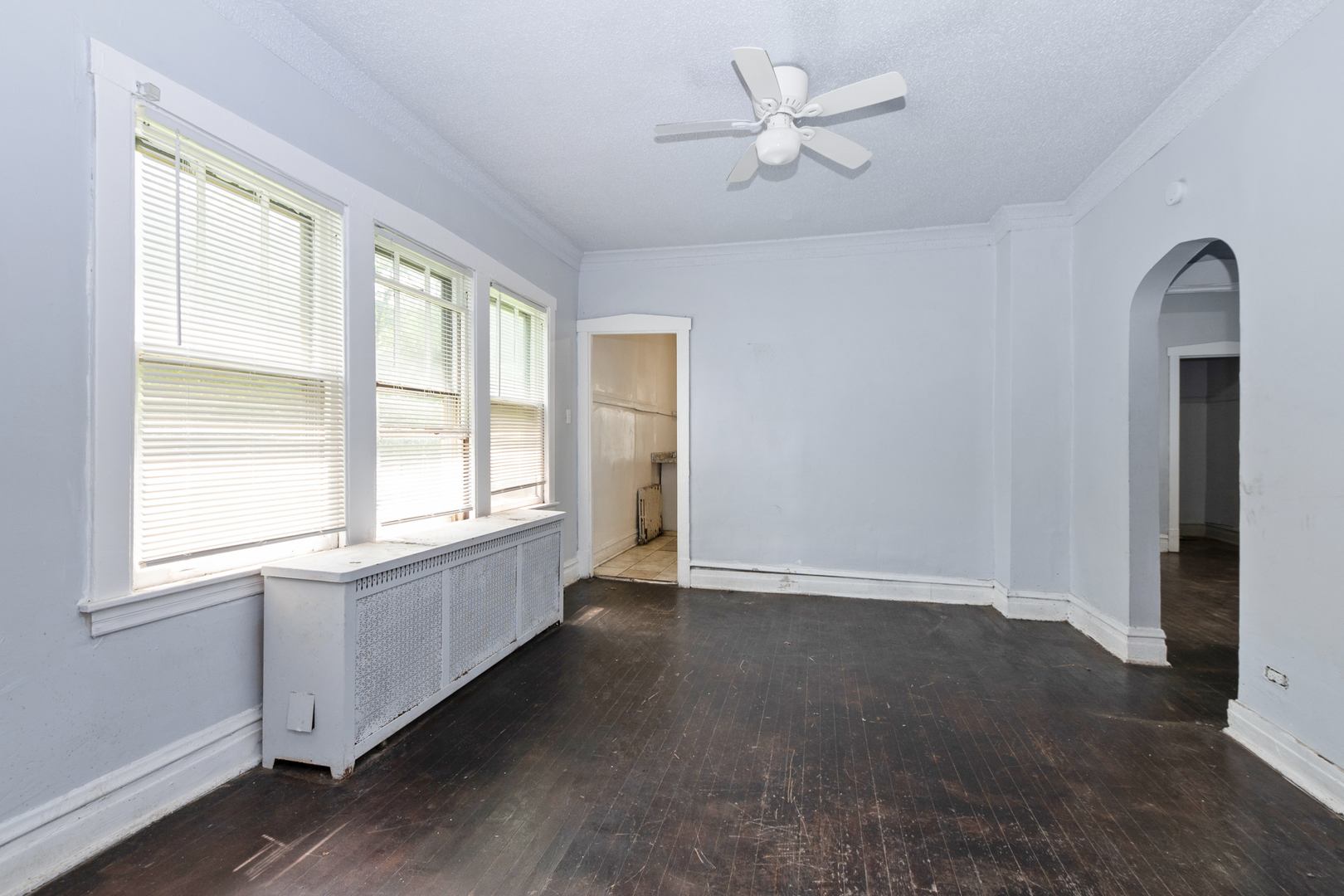 12050 South Yale Avenue Chicago, IL 60628 - Photo 7 of 24 an empty room with chandelier fan and windows