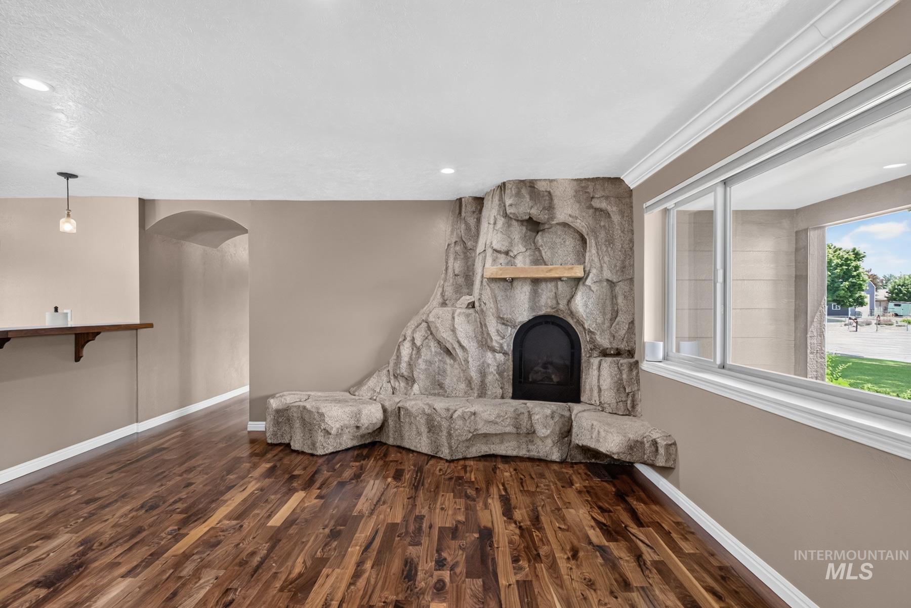 9622 Delaware Street Boise, ID 83709 - Photo 12 of 48 Focal stone-clad fireplace with hearth seating and a natural wood mantel