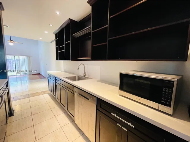 a kitchen with stainless steel appliances a sink dishwasher a stove and a microwave oven on the kitchen countertops