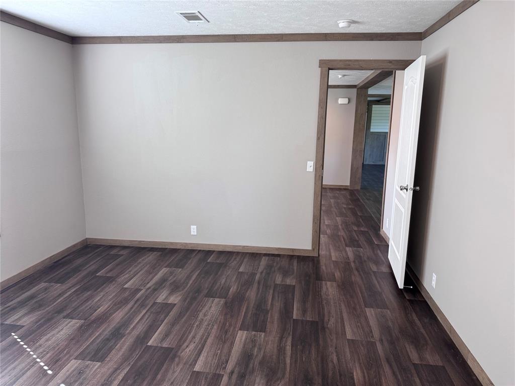 7268 Brangus Road Anna, TX 75409 - Photo 14 of 21 Interior room featuring wood-finish flooring, neutral wall paint, and contrasting wood trim