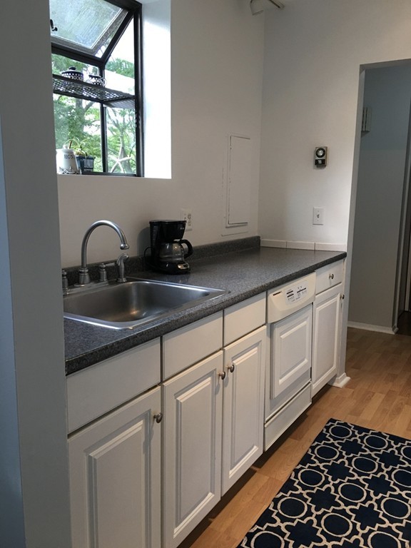 1 Round House Road, Unit 1 Bourne, MA 02532 - Photo 9 of 11 a kitchen with granite countertop white cabinets and window