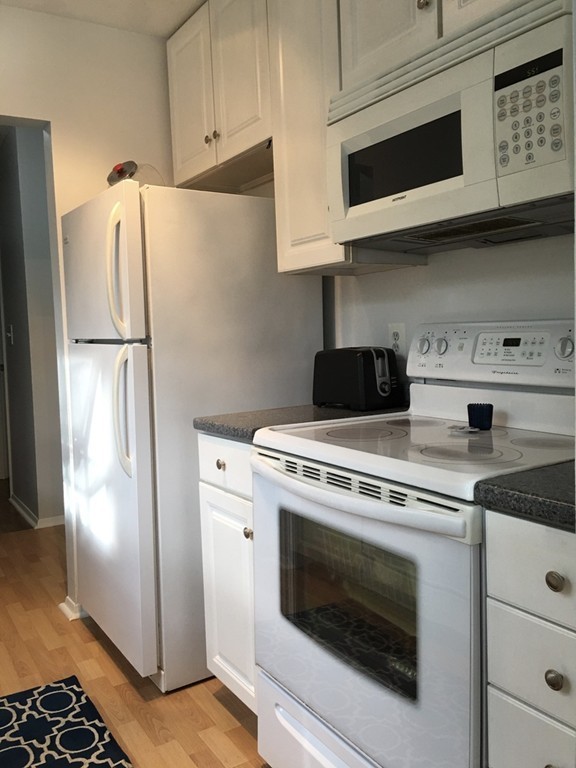 1 Round House Road, Unit 1 Bourne, MA 02532 - Photo 10 of 11 a kitchen with stainless steel appliances white cabinets white stove a refrigerator and a microwave