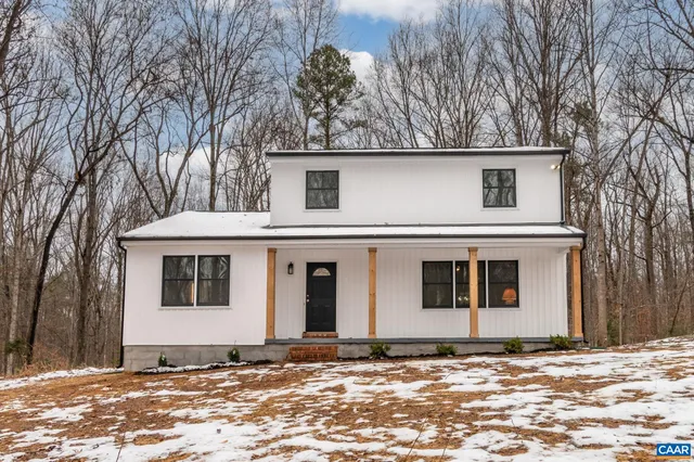 a front view of a house with a tree