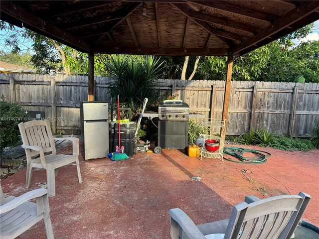 a view of outdoor space with chairs and table under an umbrella