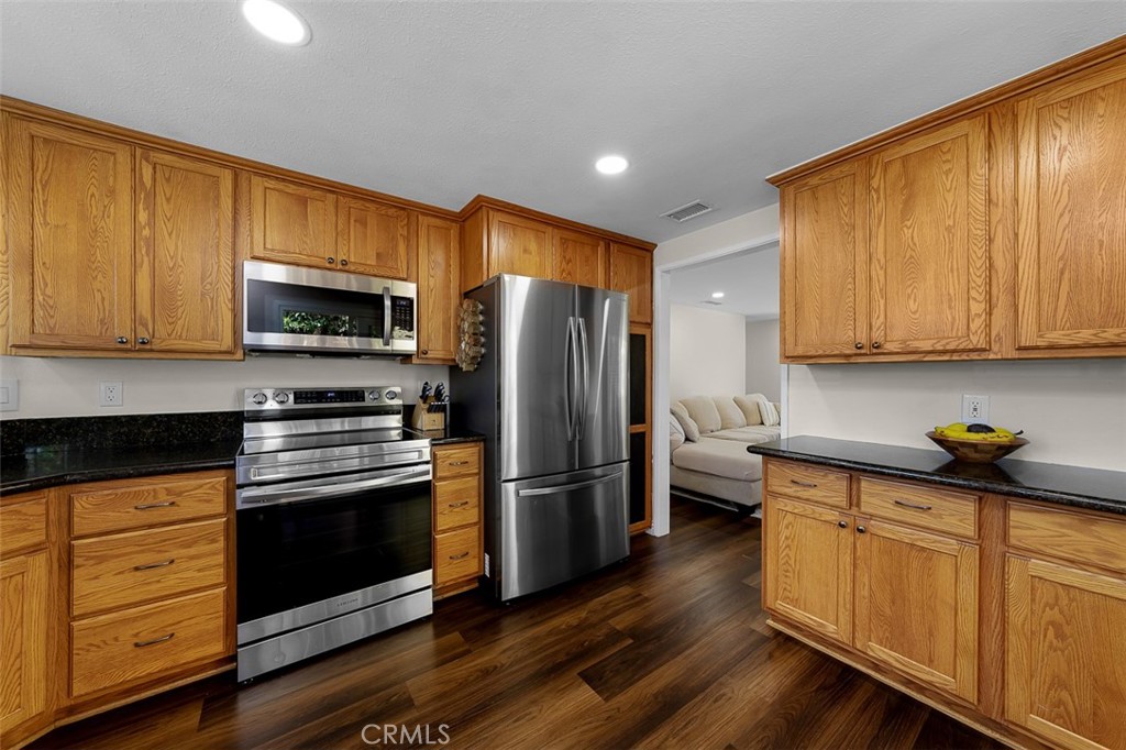 4773 Adler Way Oceanside, CA 92057 - Photo 12 of 29 a kitchen with wooden cabinets and stainless steel appliances