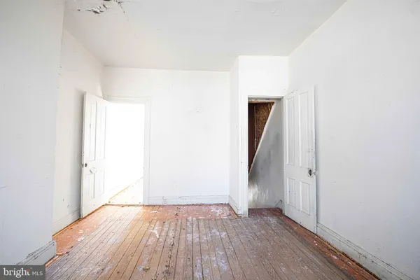 a view of a small space with wooden floor and a ceiling fan