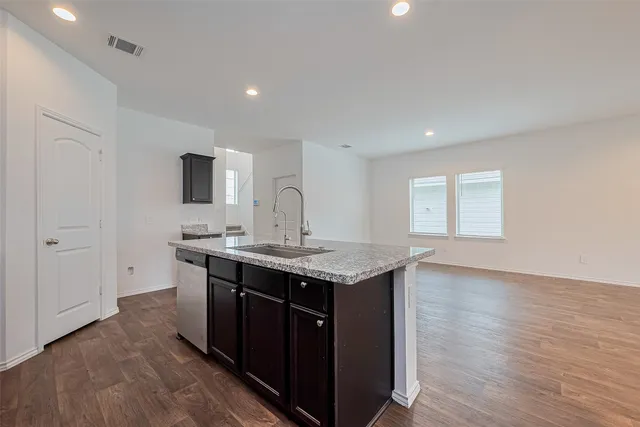 a kitchen with a sink cabinets and wooden floor