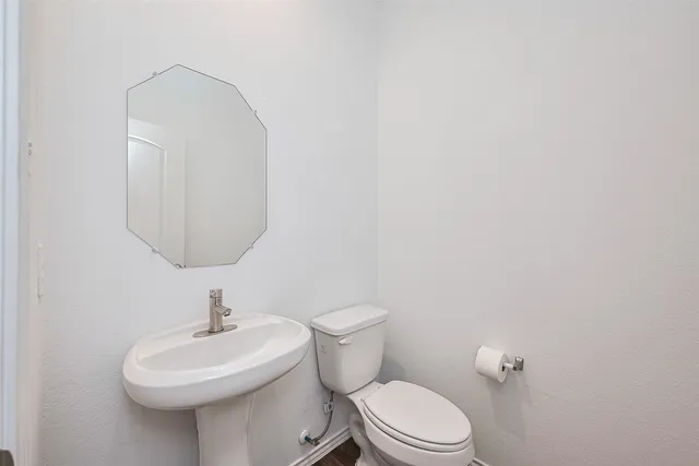 a bathroom with a toilet a sink and mirror