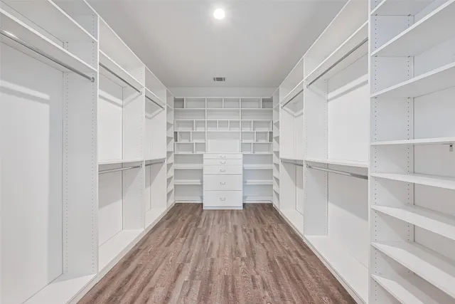 a view of walk in closet with wooden floor