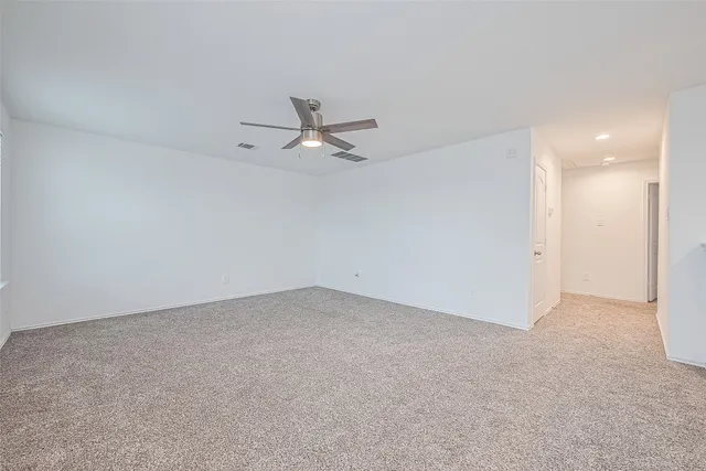 an empty room with a ceiling fan and a window
