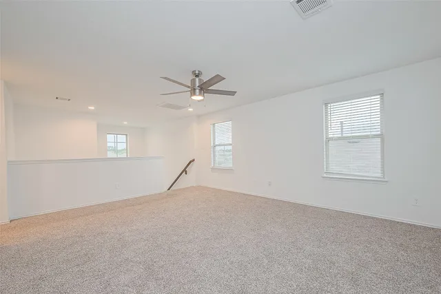 an empty room with fan and windows