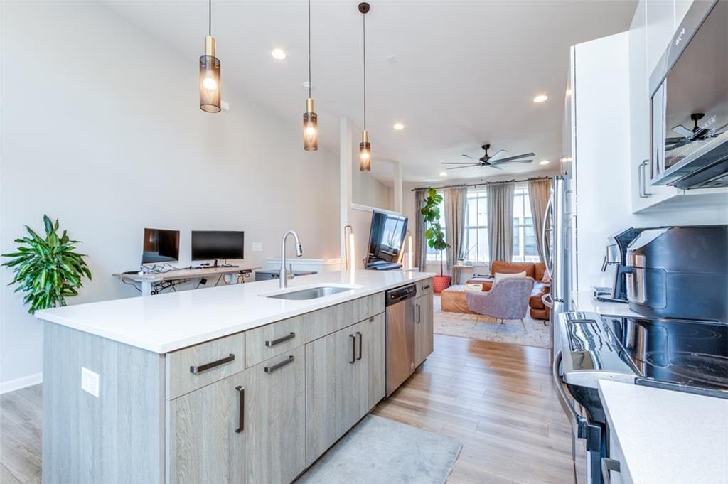 912 Brees Court Atlanta, GA 30318 - Photo 13 of 33 a large white kitchen with a stove a sink dishwasher and a refrigerator with wooden floor