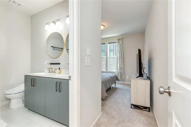 a bathroom with a sink a mirror a toilet and a mirror