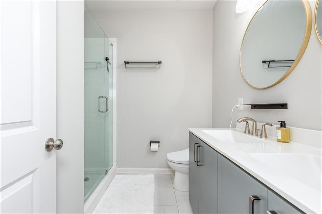 912 Brees Court Atlanta, GA 30318 - Photo 26 of 33 a bathroom with a sink a mirror a toilet and a mirror