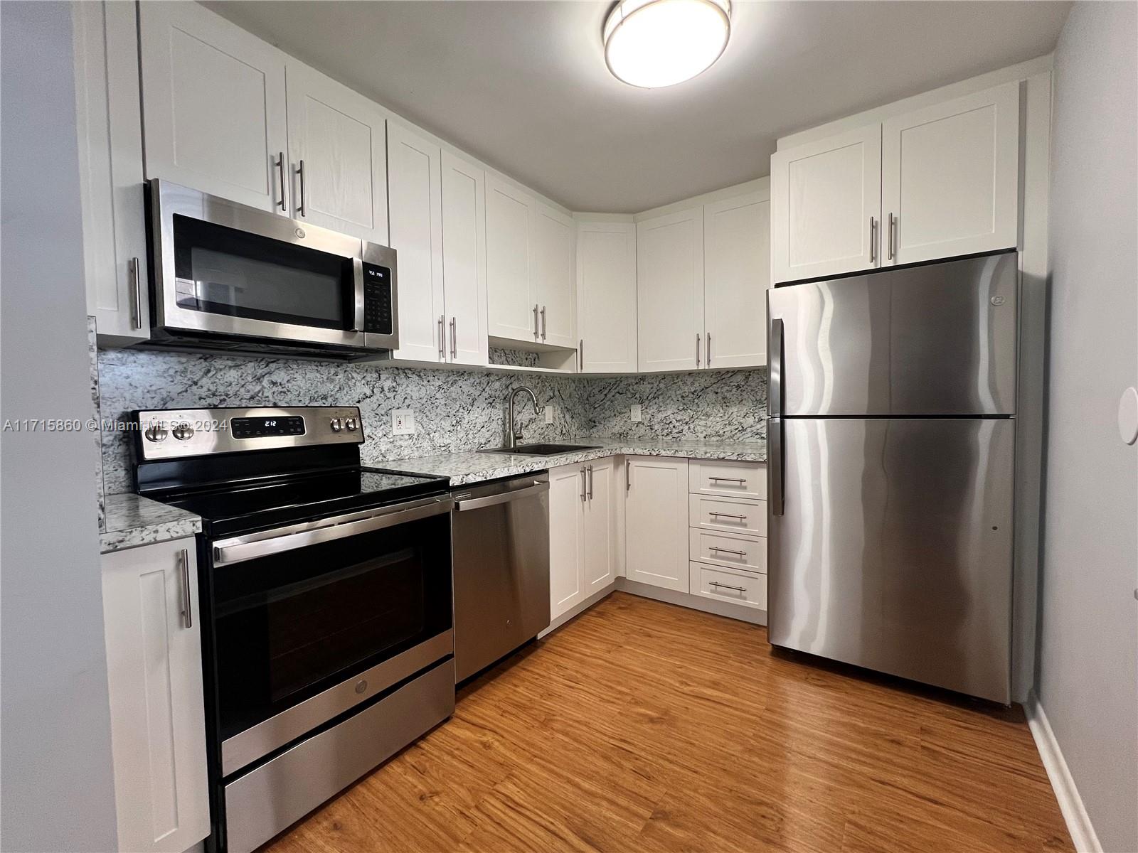 8281 Southwest 128th Street, Unit 213 Pinecrest, FL 33156 - Photo 1 of 8 a kitchen with a refrigerator stove and microwave