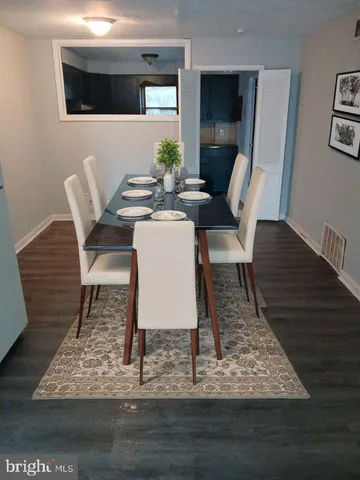 a dining room with furniture mirror and wooden floor