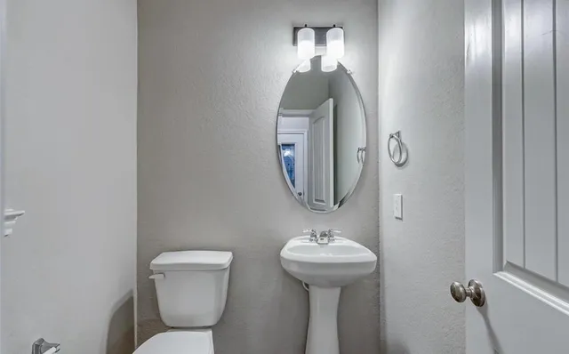 a bathroom with a toilet sink and mirror