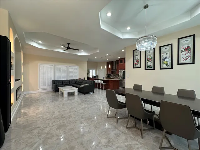 a living room with furniture a chandelier and a flat screen tv