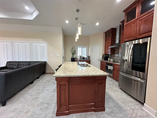 a kitchen with stainless steel appliances granite countertop a stove a refrigerator and a sink