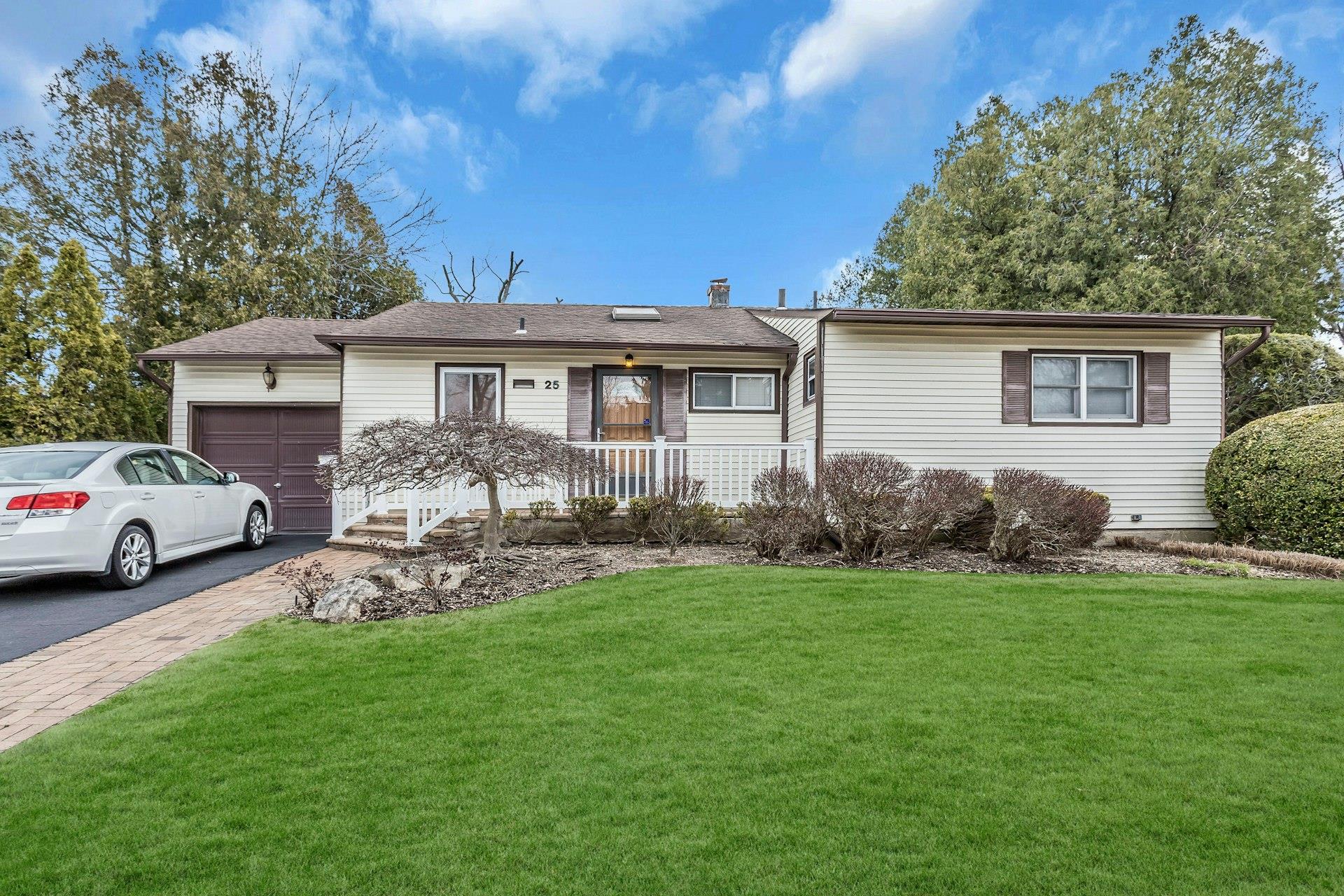 25 Mitchell Avenue Plainview, NY 11803 - Photo 1 of 1 Ranch-style house featuring covered porch, driveway, a front lawn, and an attached garage