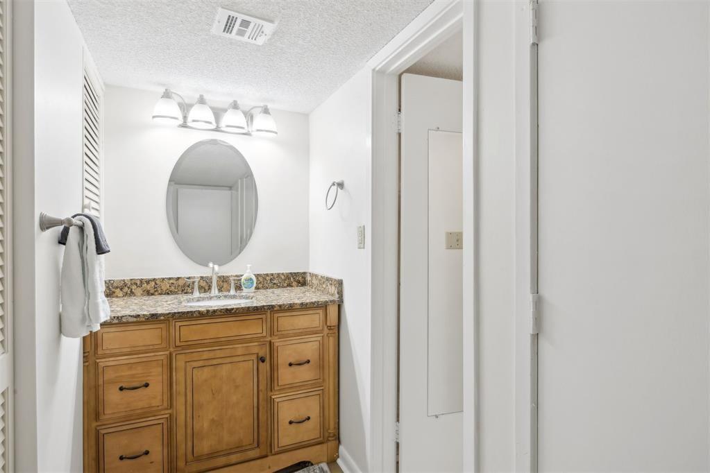 2021 Beachwood Road, Unit 2021 Fernandina Beach, FL 32034 - Photo 14 of 32 a bathroom with a granite countertop sink a mirror and a vanity