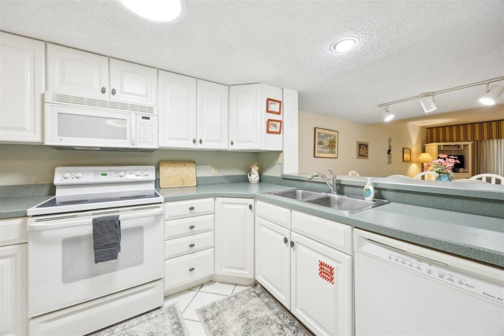 2021 Beachwood Road, Unit 2021 Fernandina Beach, FL 32034 - Photo 9 of 32 a kitchen with granite countertop white cabinets and white appliances