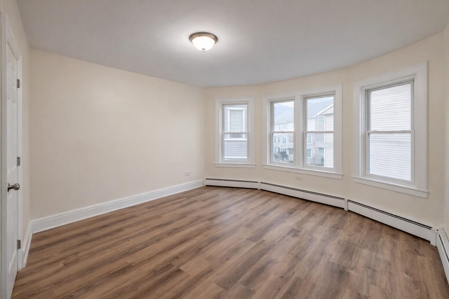 64 South 13th Street, Unit 2 Newark, NJ 07107 - Photo 8 of 11 an empty room with wooden floor and windows