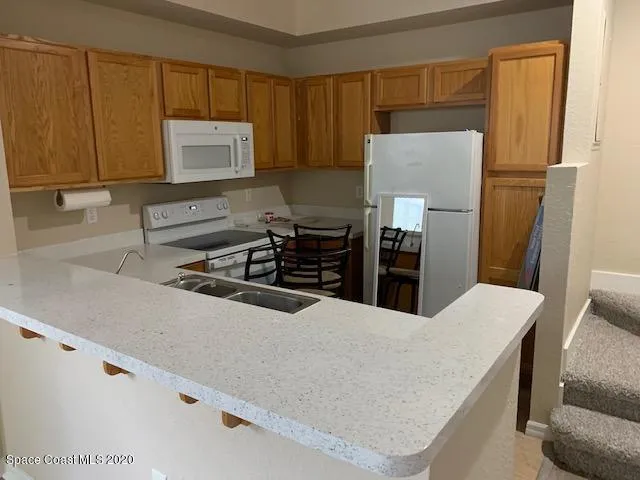 a kitchen with a refrigerator and a stove top oven